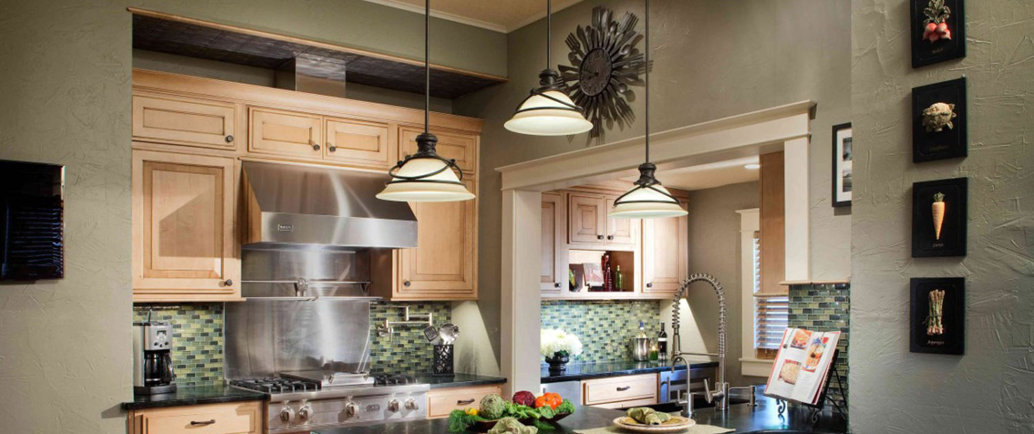 Specialty Products task lighting pendants over eating space in kitchen with green glass backsplash and light cabinets | Marchand Creative Kitchens Cabinets, Marchand Creative Kitchens, Cabinets, New Orleans, Metairie, Mandeville, Kenner, Covington, Slidell, Lacombe, North Shore, South Shore, Kitchen, kitchen remodel, kitchen renovation