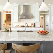 white cabinets, veined countertops, stainless appliances, island with seating | Marchand Creative Kitchens Cabinets New Orleans Metairie Mandeville LA